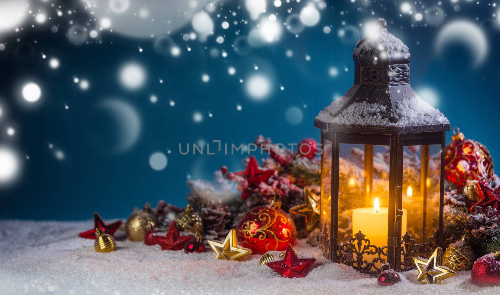 Burning candles , lantern and christmas decoration on magic bokeh lights background