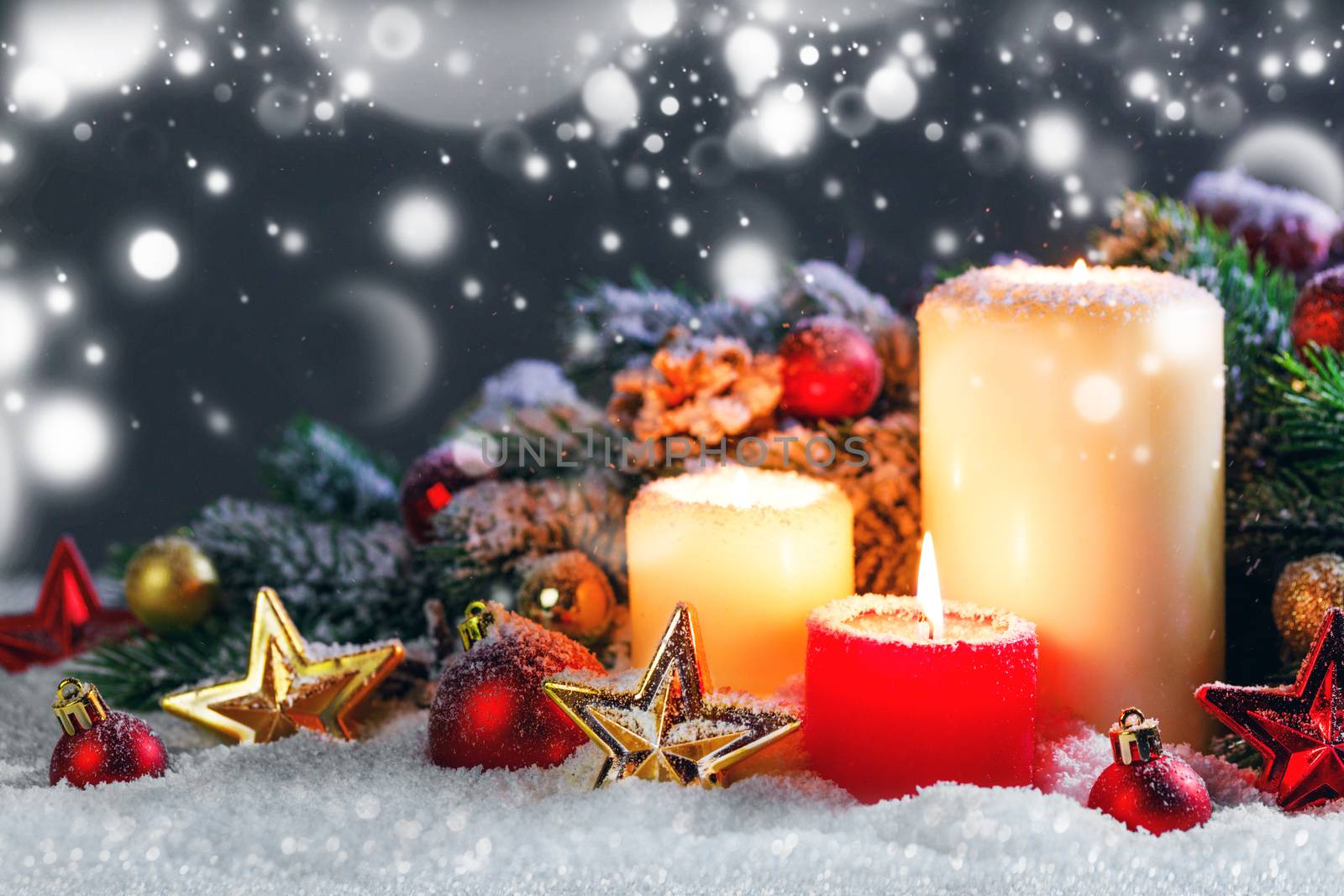 Christmas candles with traditional decorative stars , red baubles , pine cones and green branches on snow