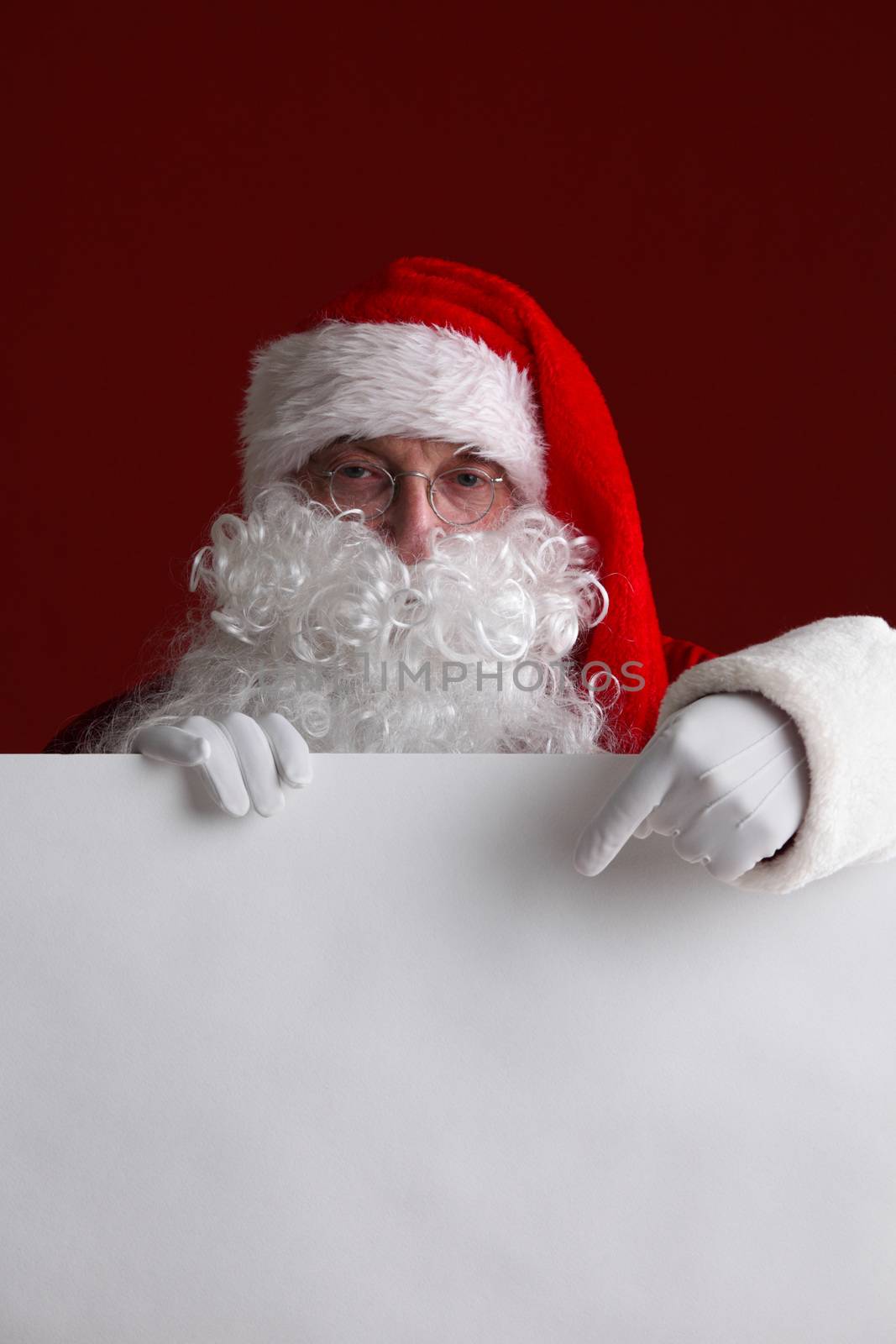 Santa Claus holding white paper billboard with copy space for text