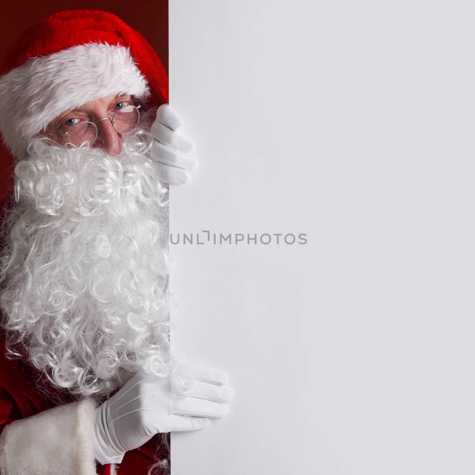 Santa Claus holding white paper billboard with copy space for text