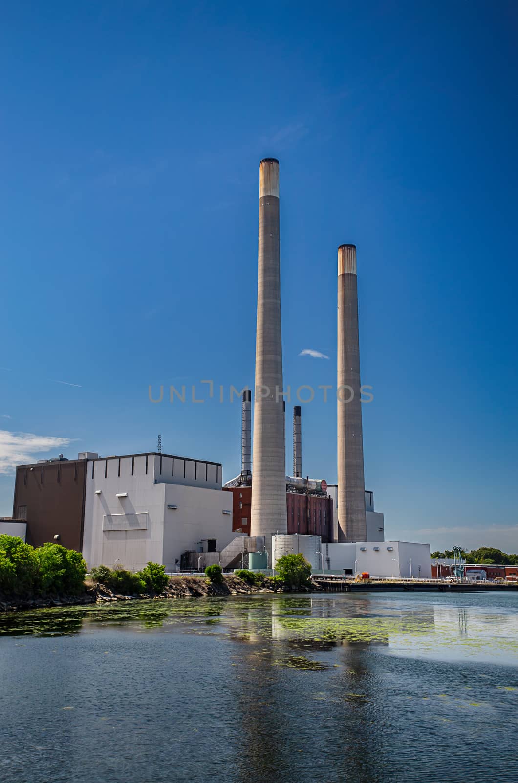 Industrial building with long chimney by the water