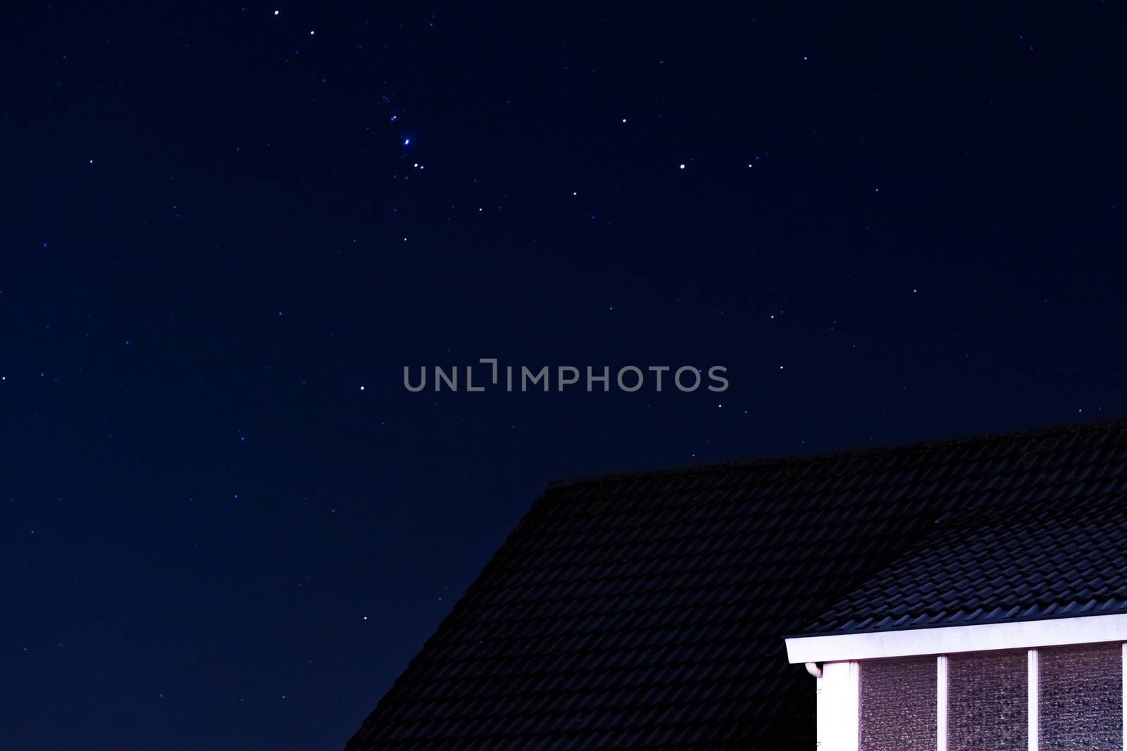 pointy house rooftop with a sky full of stars at night