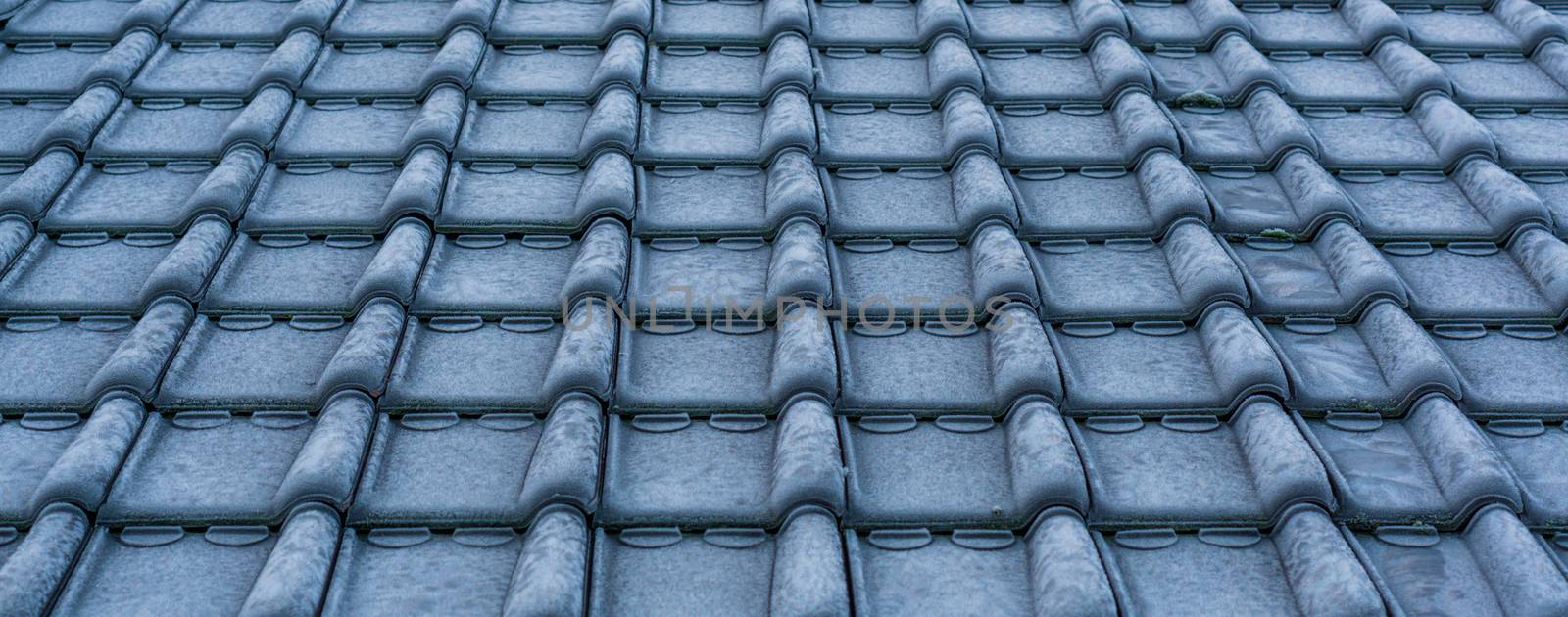 pattern of frozen rooftop tiling in macro closeup, cold winter season, architecture background