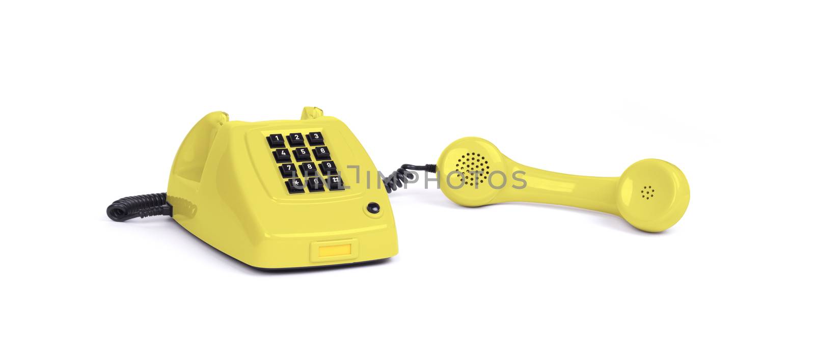 Vintage yellow telephone with a white background