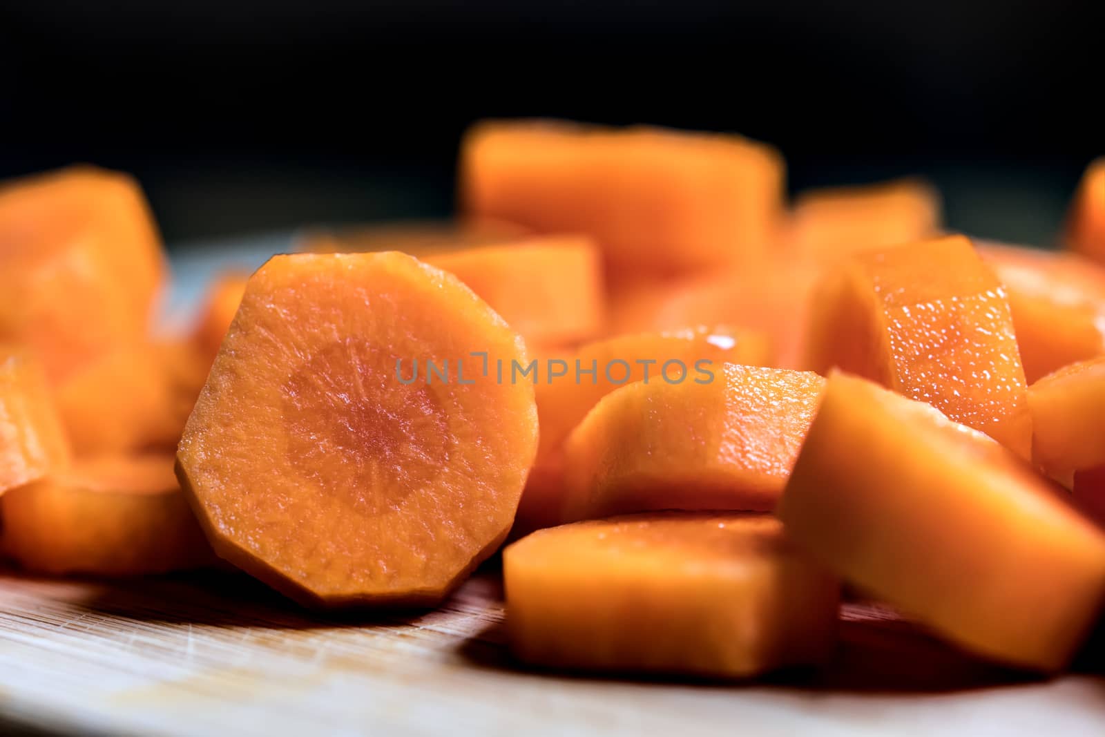 Closeup of orange carrot slices on a table with dark background