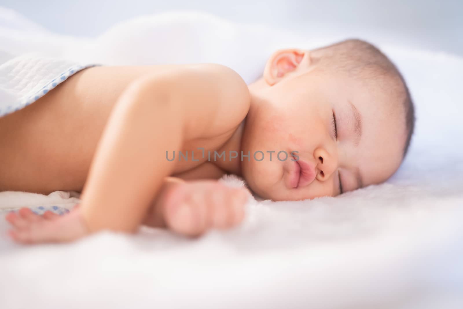 portrait asia baby on white bed by Wmpix