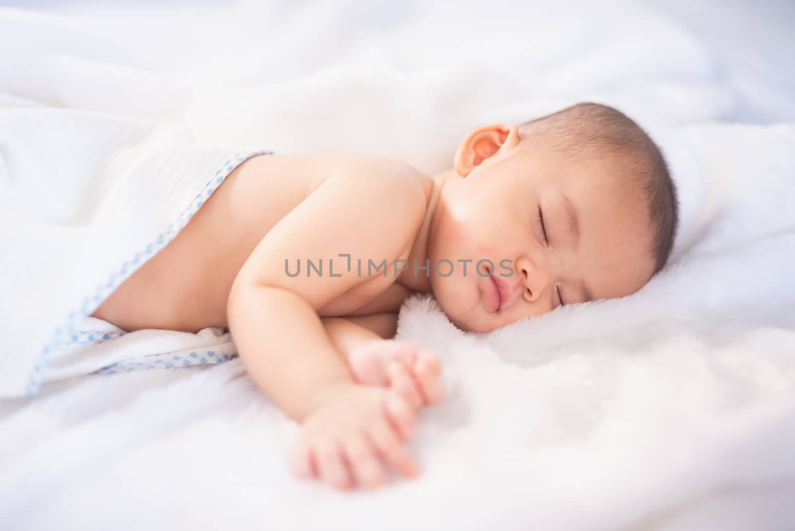 portrait asia baby on white bed by Wmpix