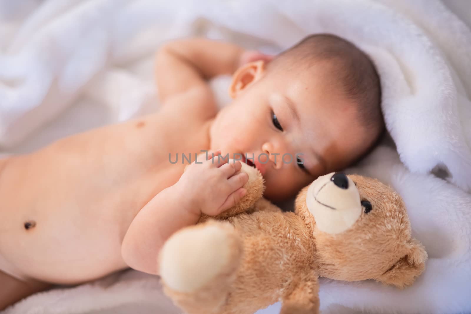 portrait asia baby on white bed by Wmpix