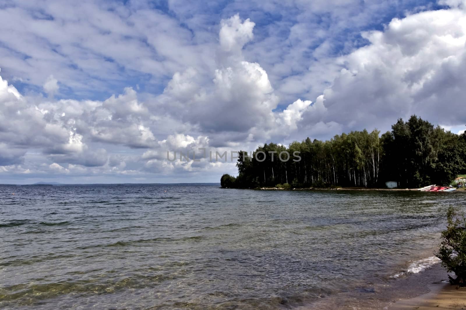 blue sky with powerful cumulonimbus clouds over the lake