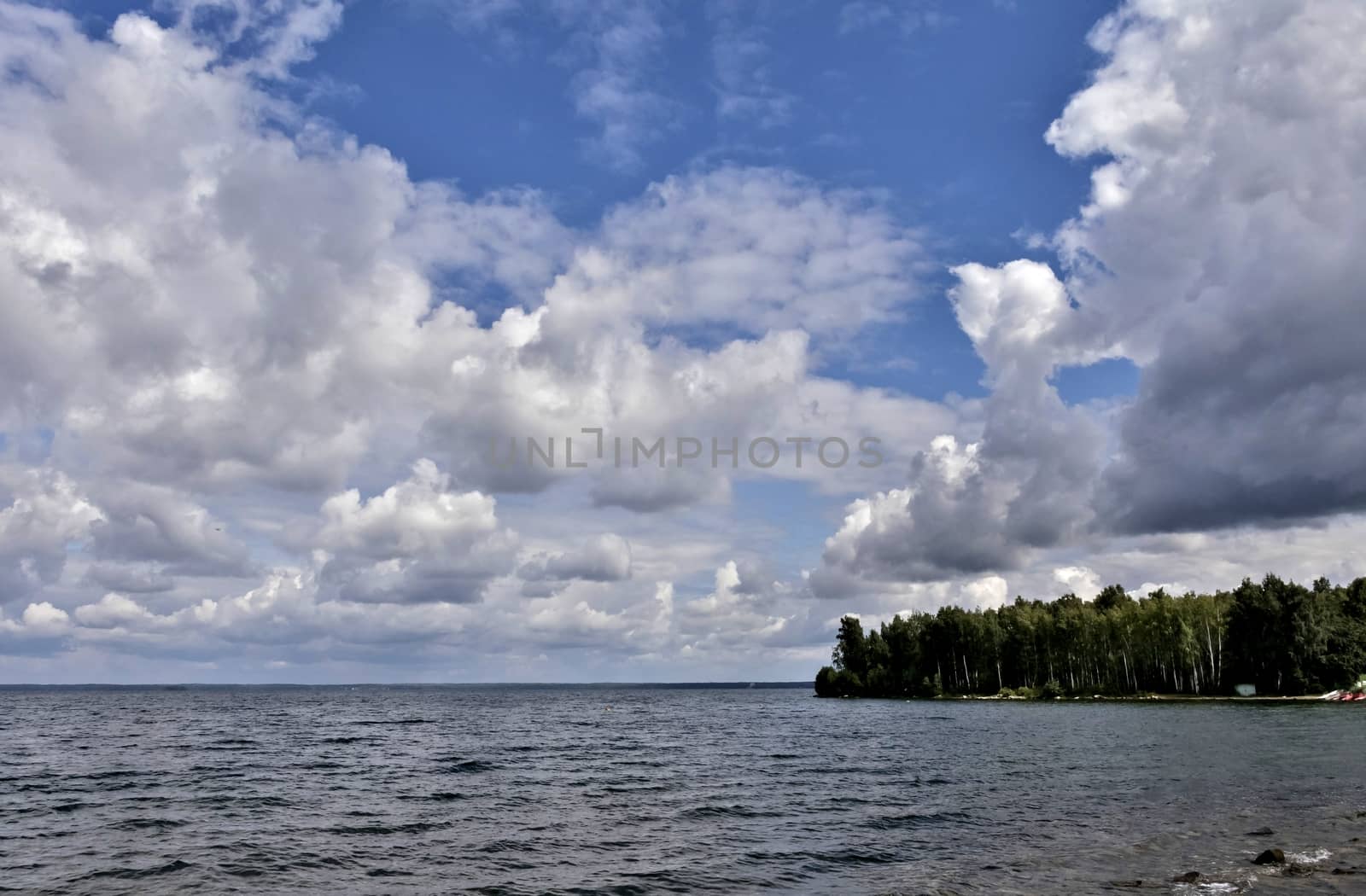 blue sky with powerful cumulonimbus clouds over the lake