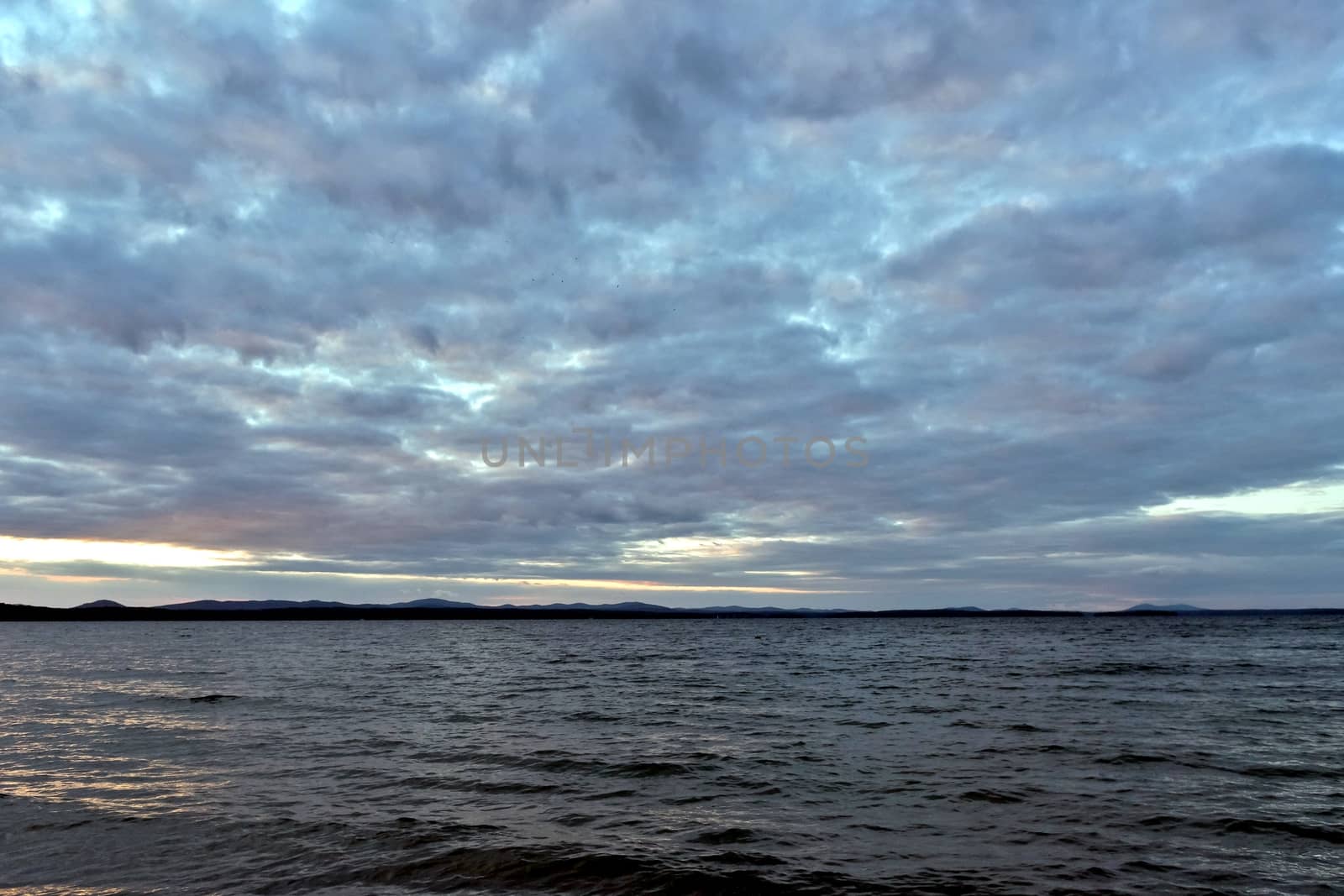 evening lake in cloudy weather, South Ural, Uvildy, in the distance are seen the Ural mountains