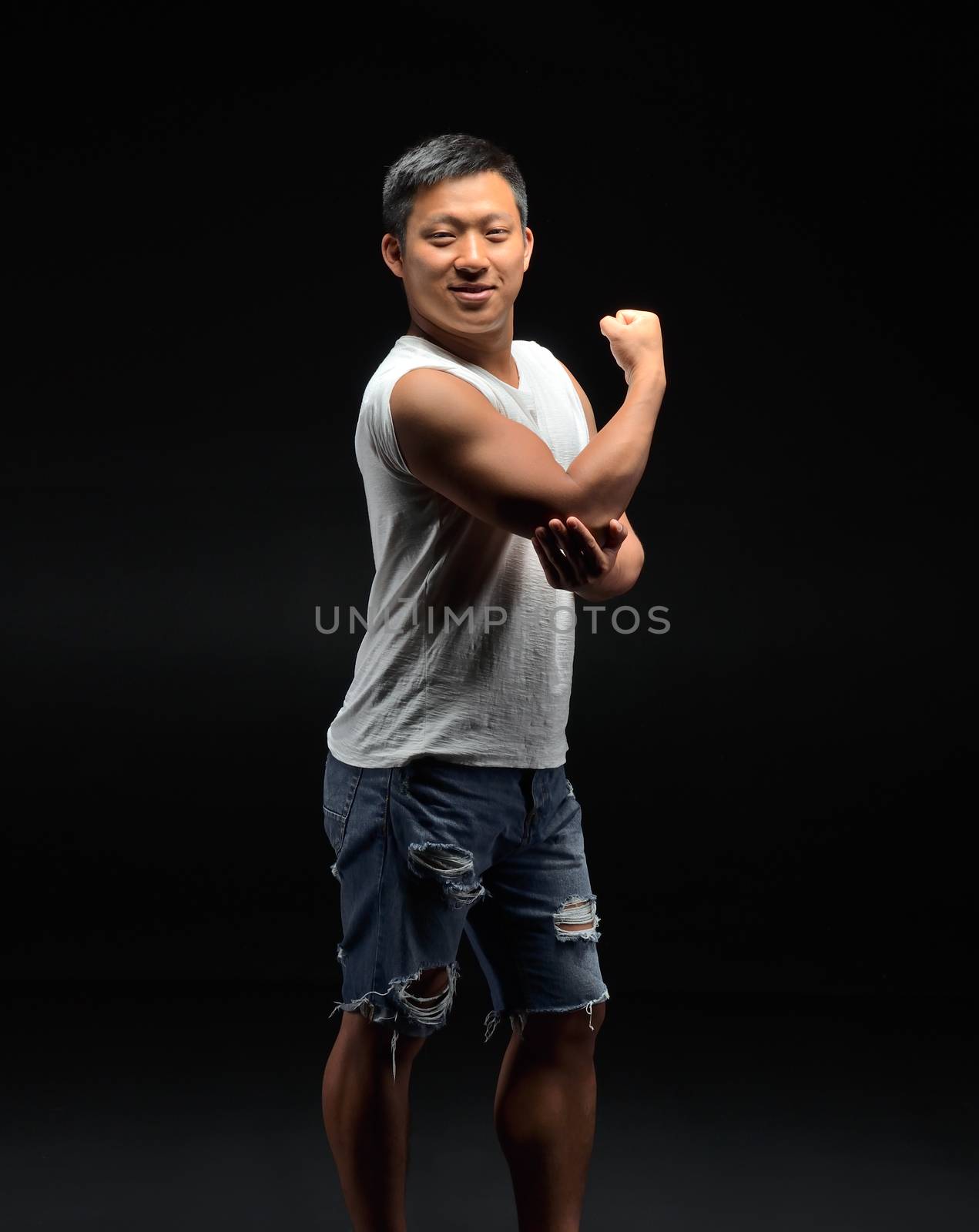 Portrait of a male Asian student of appearance on a black background that shows a bisebce