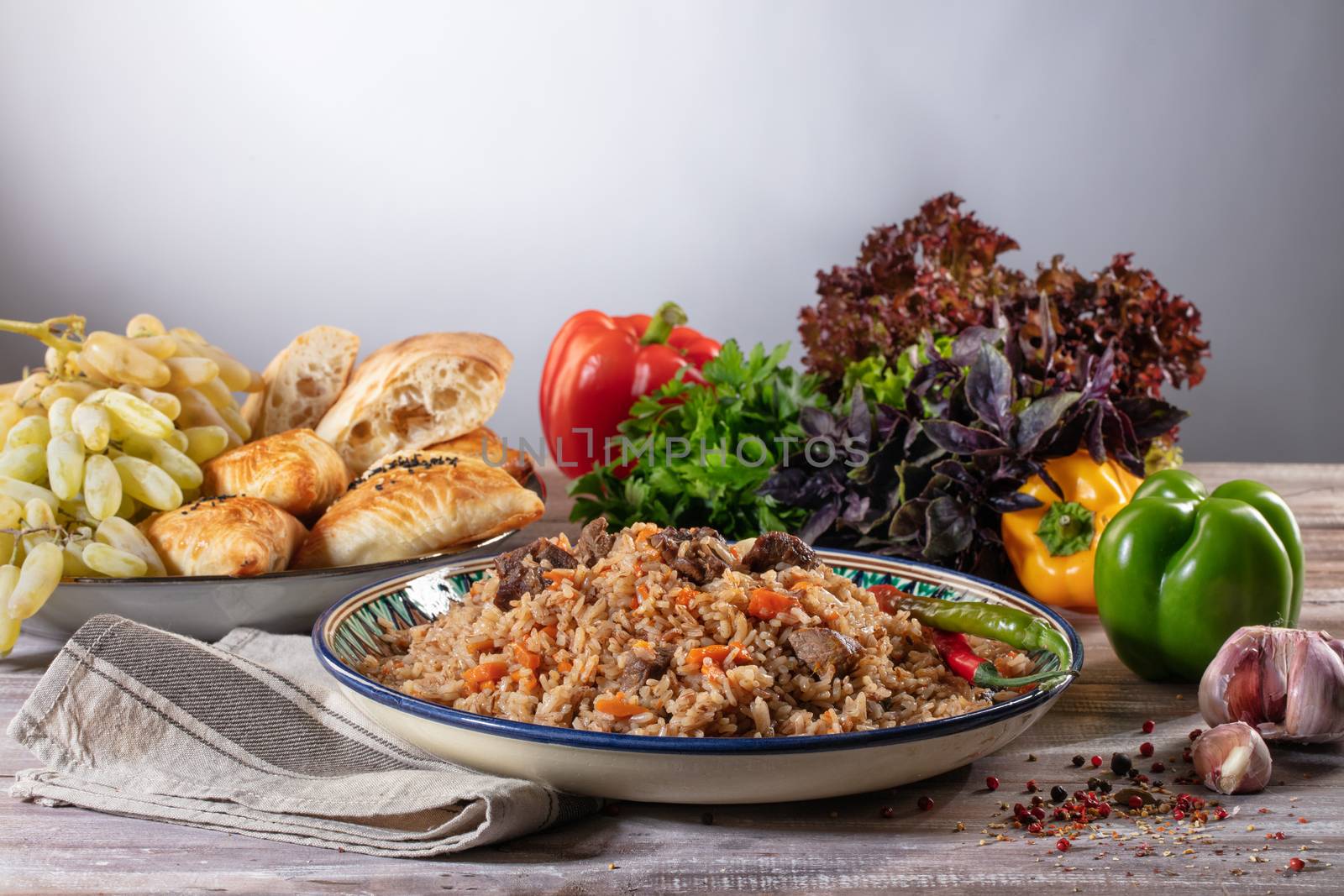 Asian traditional pilaw and vegetables on a wooden table