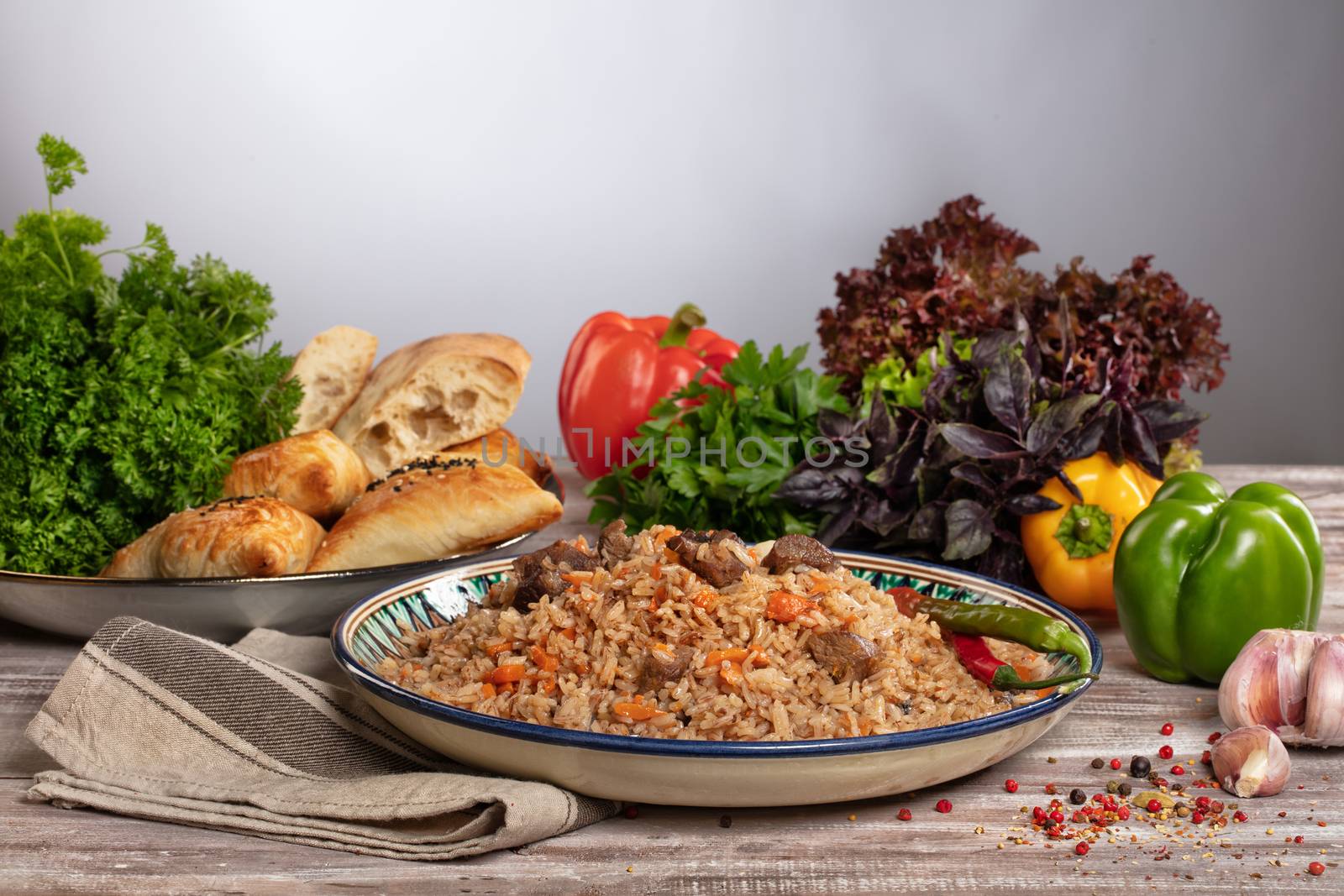 Asian traditional pilaw and vegetables on a wooden table