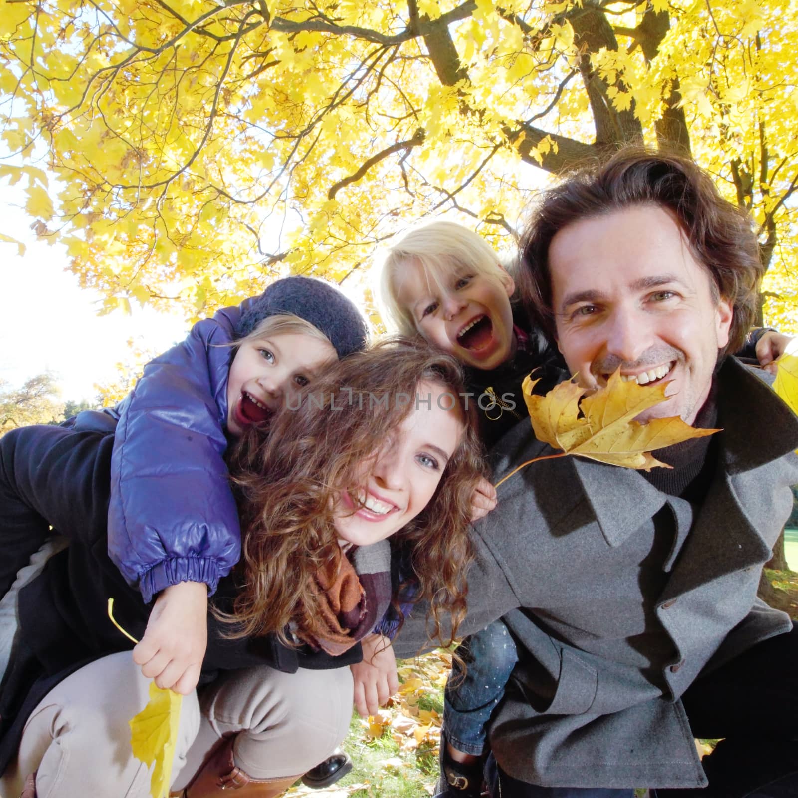 Parents and children having fun in yellow autumn park