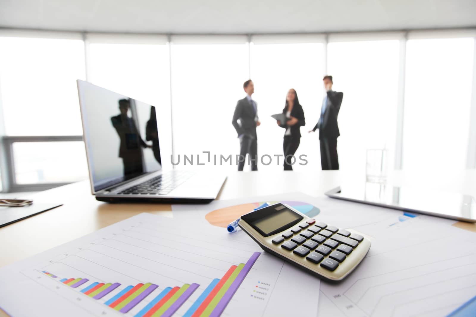 Businessmen in office with table with laptop and financial documents with diagrams 