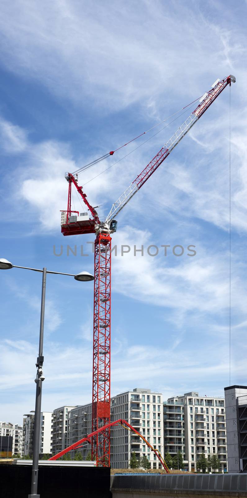 tall red crane and apartments by morrbyte