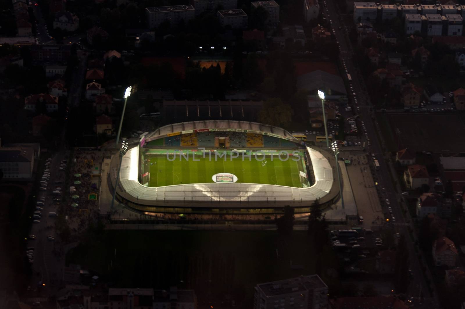 Aerial view of illuminated footbal stadium at dusk by asafaric