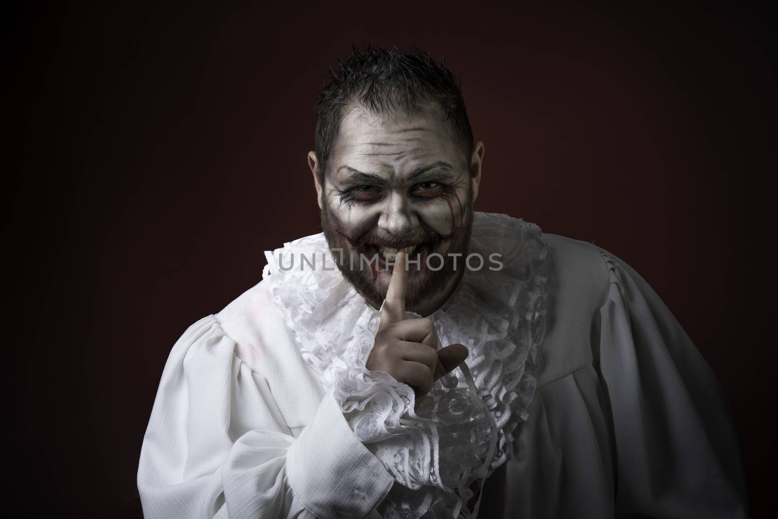 Portrait of a Scary Evil Clown.  Studio shot with horrible face art