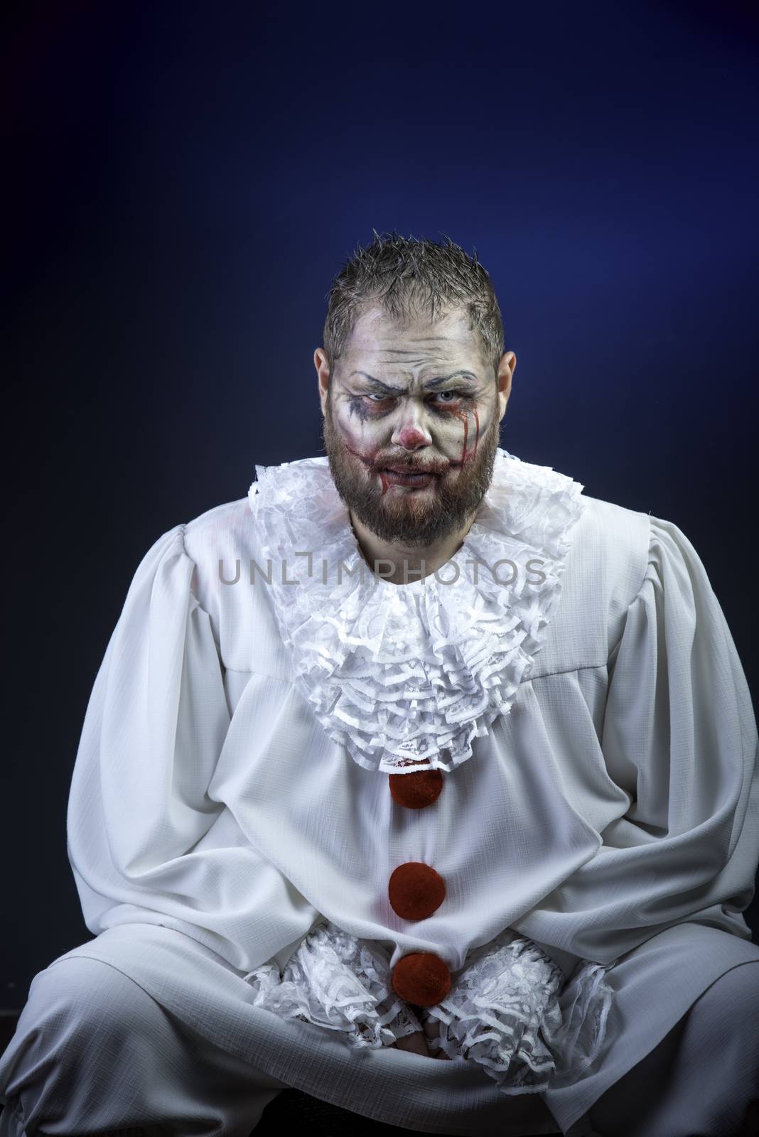 Portrait of a Scary Evil Clown.  Studio shot with horrible face art