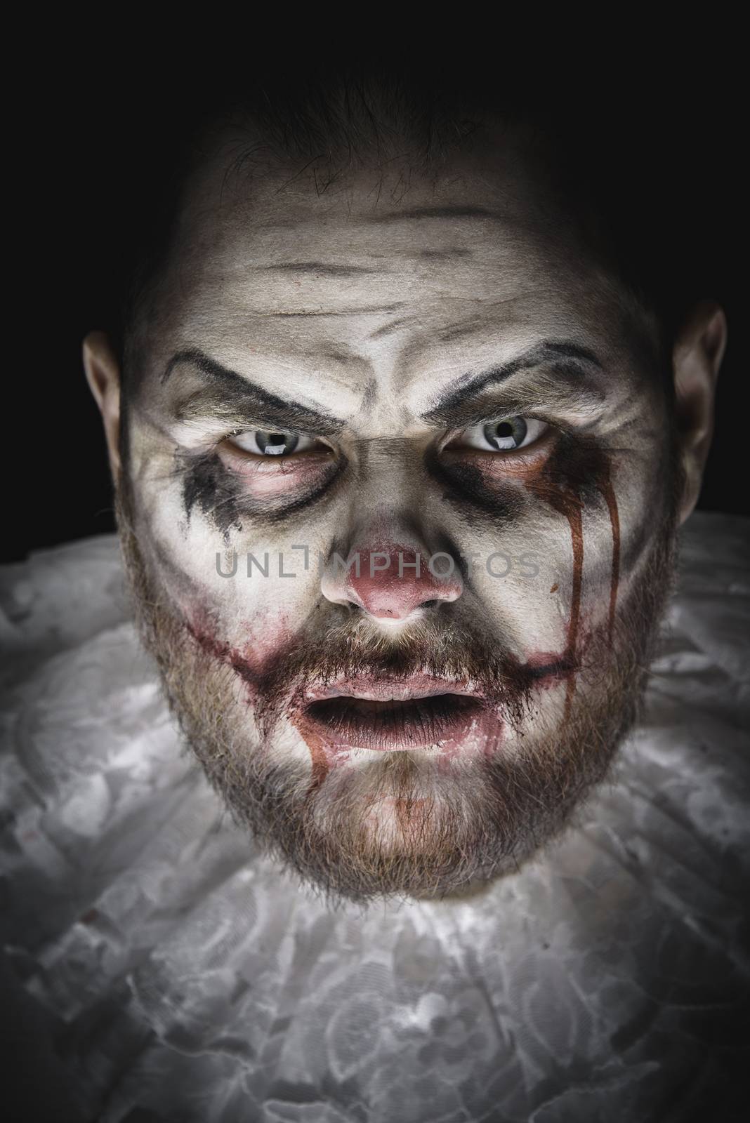 Portrait of a Scary Evil Clown.  Studio shot with horrible face art