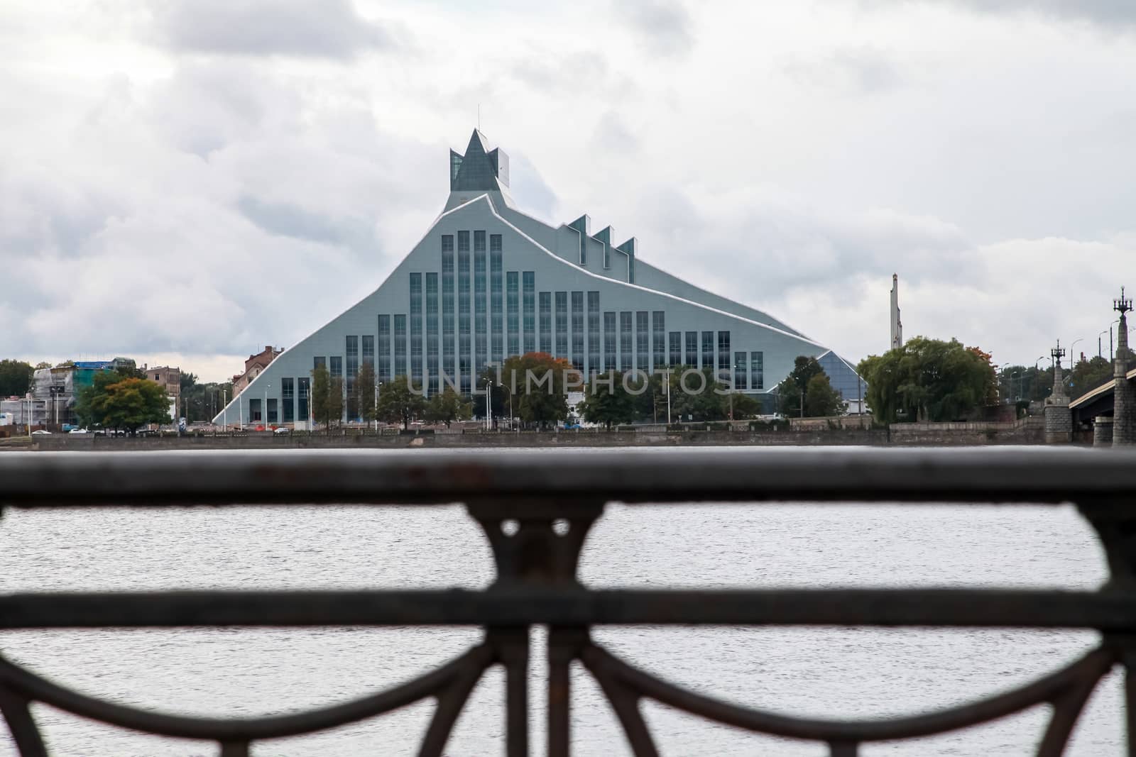 Latvian National Library. Cityscape from November 11 embankment with Latvian National Library in Riga. November 11 embankment bridge railings and National Library. National Library in center of Riga.