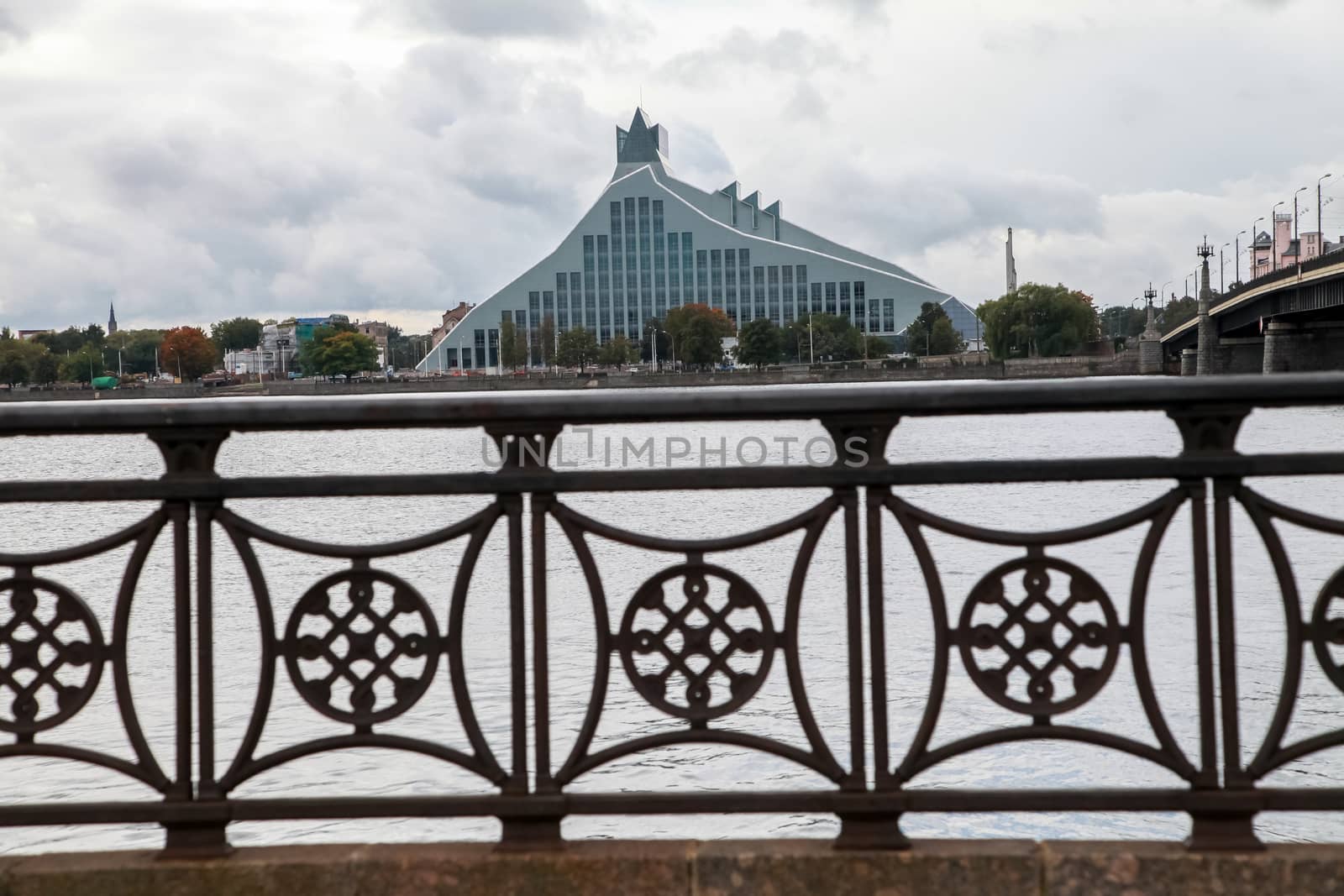 Latvian National Library. Cityscape from November 11 embankment with Latvian National Library in Riga. November 11 embankment bridge railings and National Library. National Library in center of Riga.
