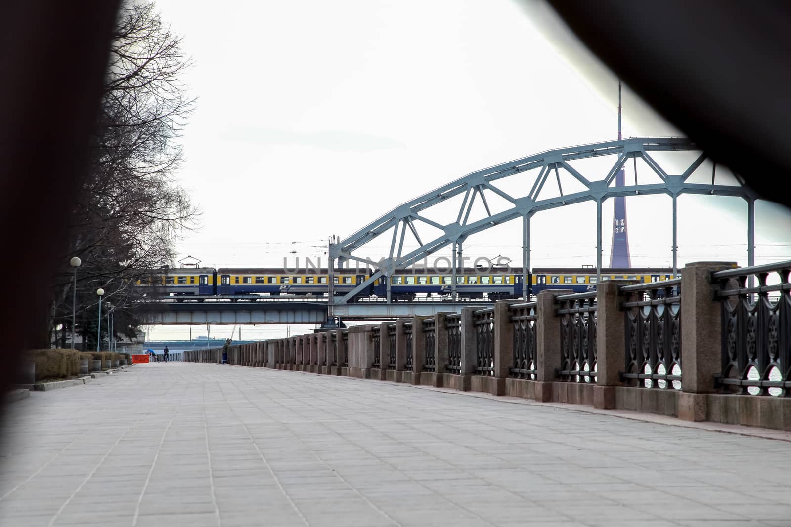 View of the Railway bridge from the 11th November Embankment, Riga, Latvia. Behind the railway bridge can see the television tower. Bridge crossing train. 