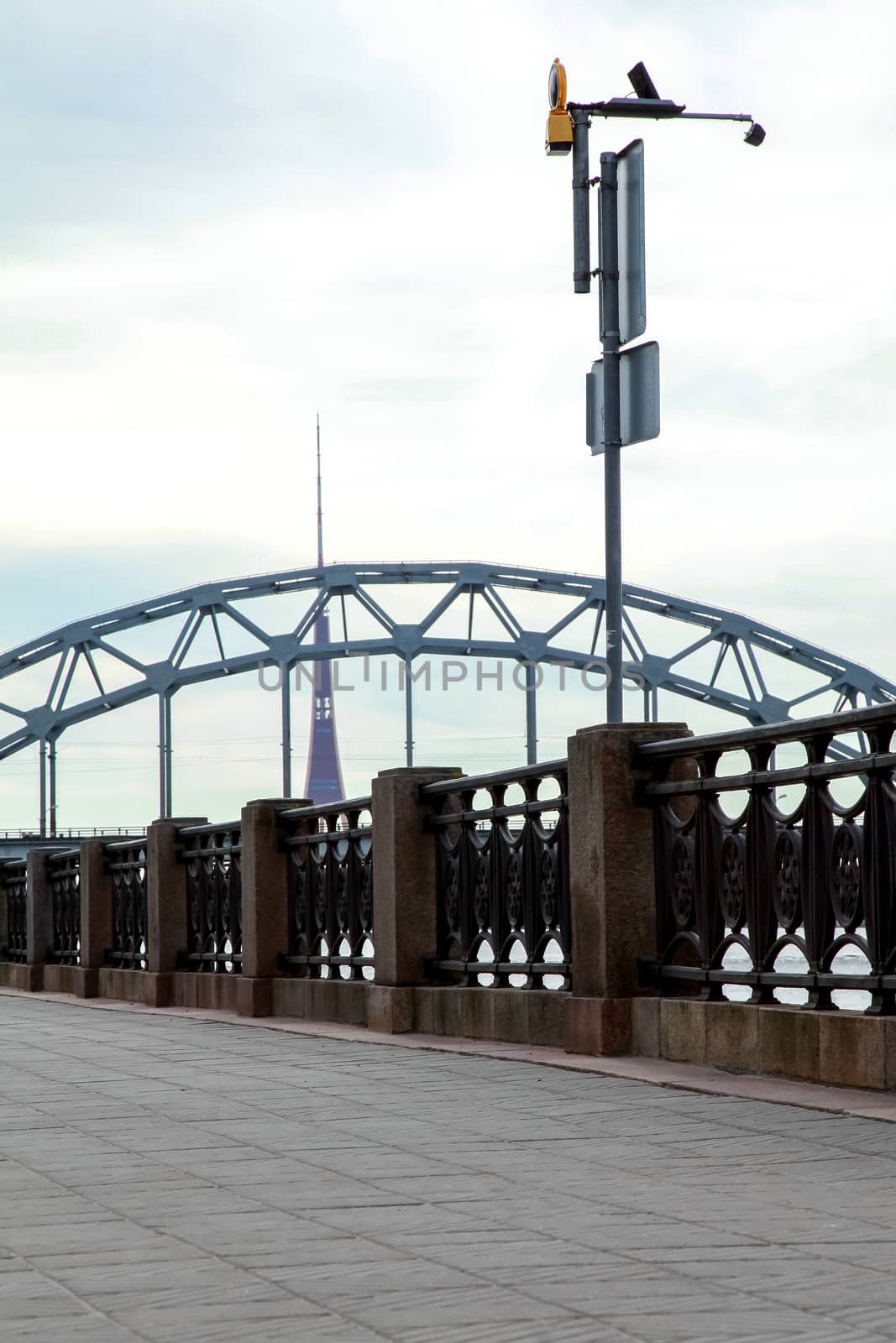View of the Railway bridge from the 11th November Embankment in Riga, Latvia. Behind the railway bridge can see the television tower. Bridge crossing train. 