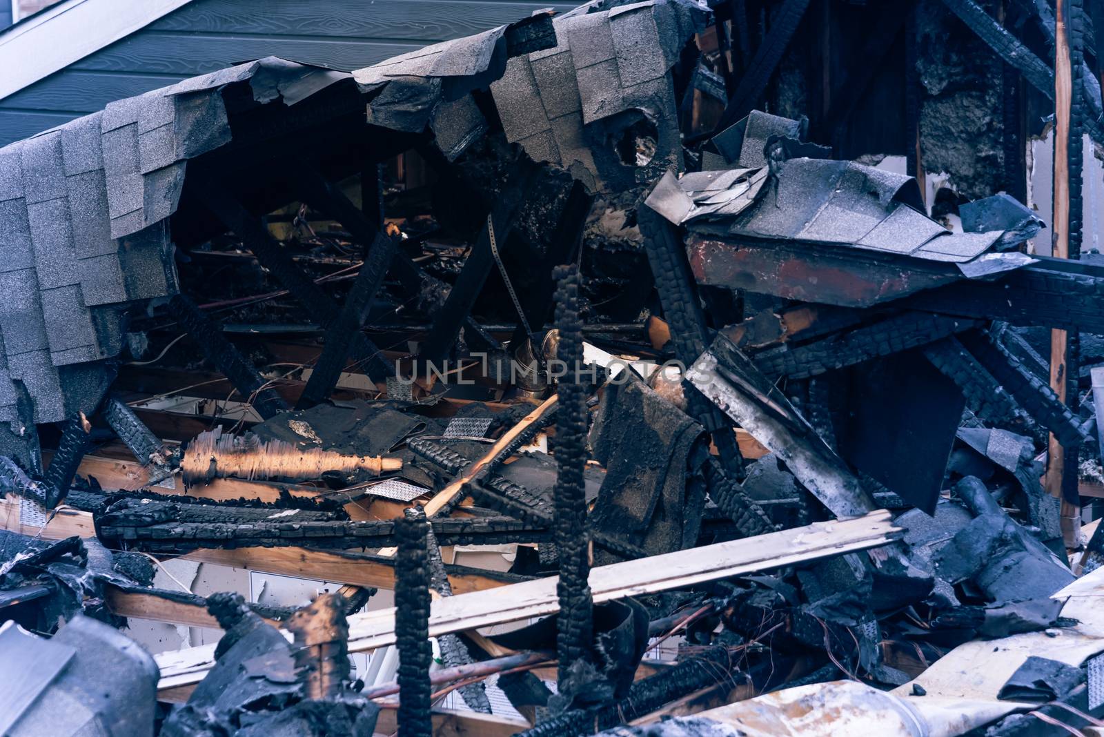 Close-up the roof of damaged apartment after burned by fire in Texas, America. Smoke and dust in burn scene of arson investigation course. Insurance theme of fire devastated
