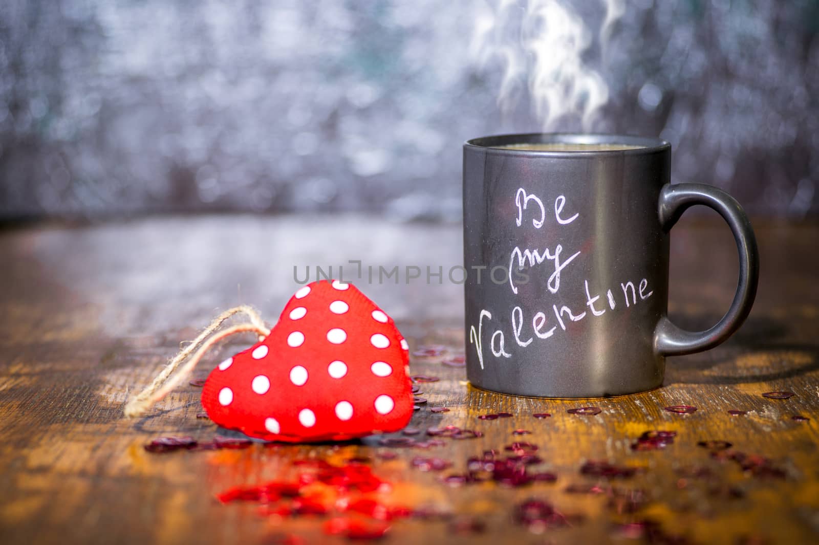 Valentine's day concept with black cup, chalk inscription on a mug and a red heart.