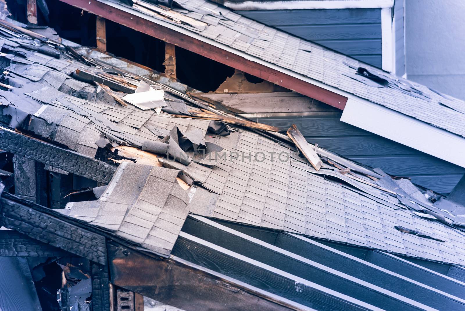 Close-up the roof of damaged apartment after burned by fire in Texas, America. Smoke and dust in burn scene of arson investigation course. Insurance theme of fire devastated