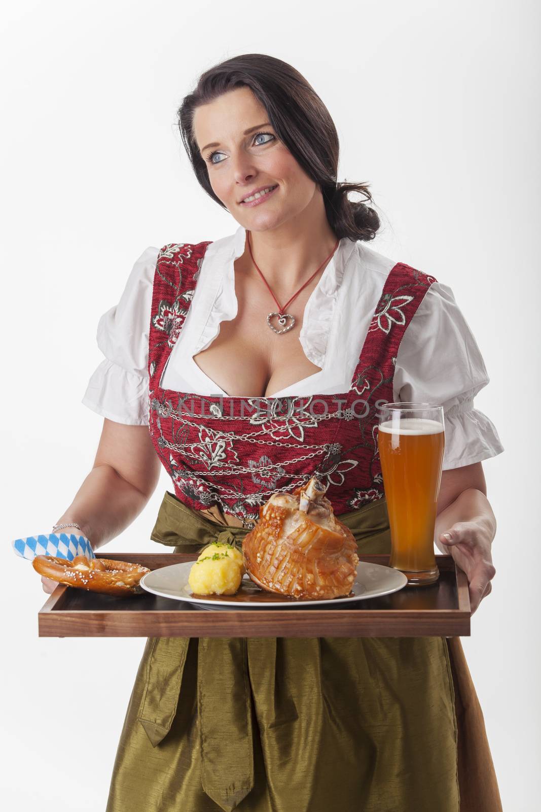 bavarian woman in a dirndl serving food by bernjuer
