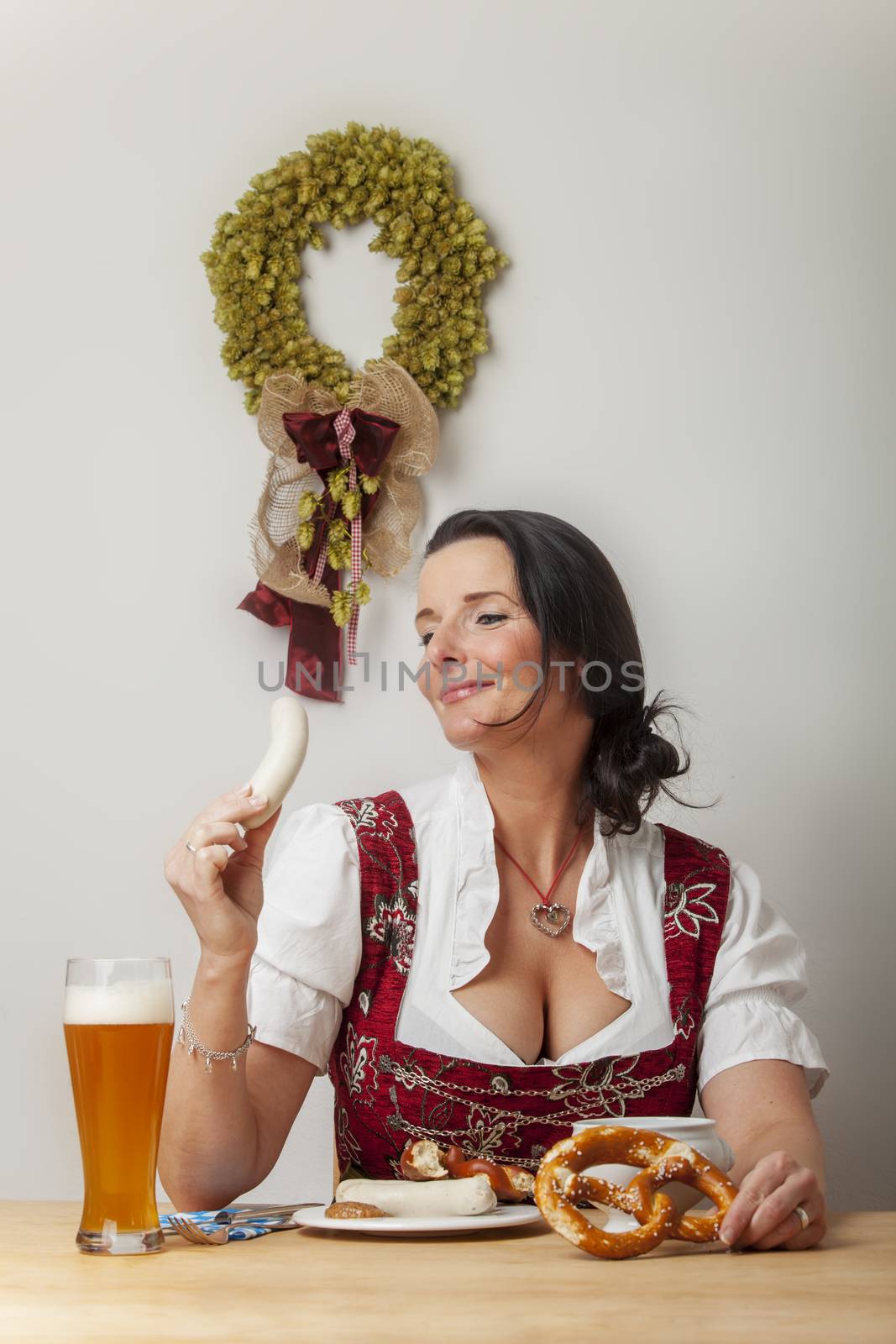 bavarian woman in a dirndl eating by bernjuer