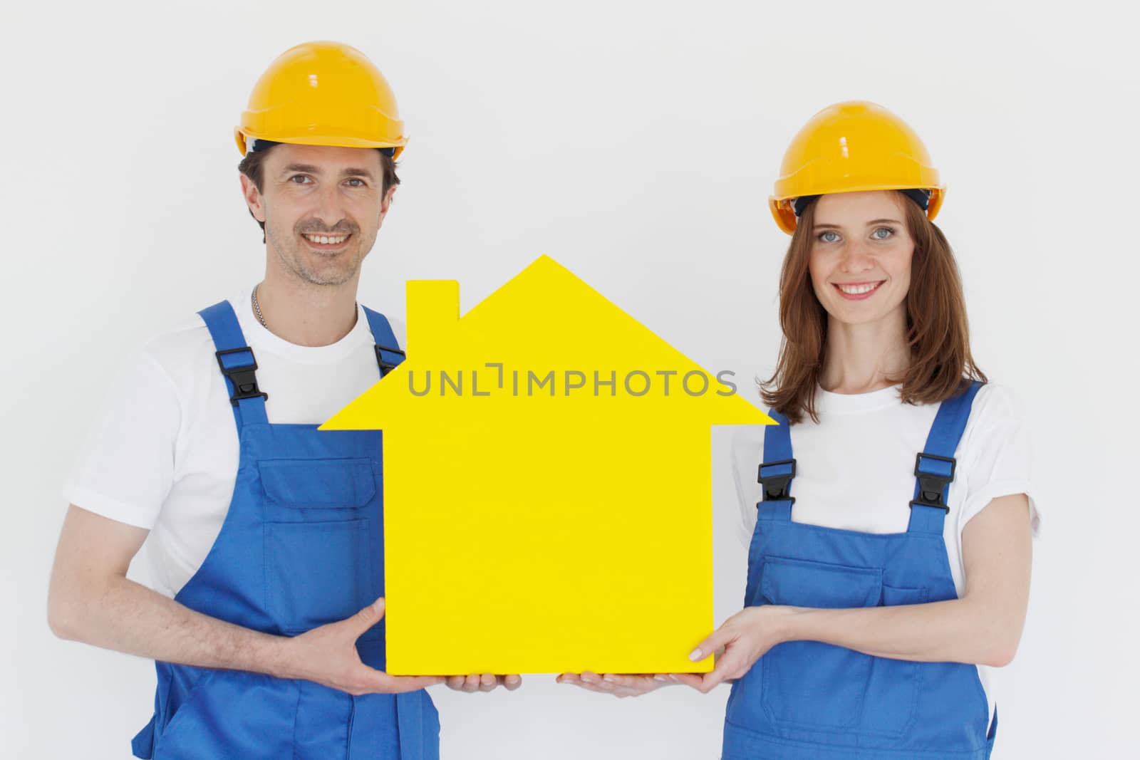 Construction workers showing house model symbol and friendly smiling