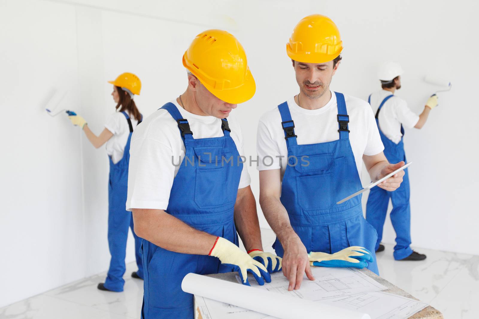 Workers discuss renovation project using digital tablet