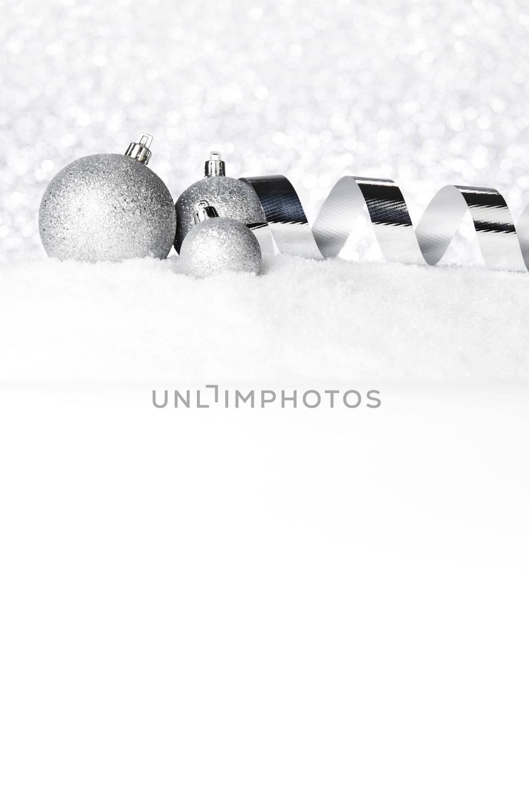 Silver Christmas decorations on snow close-up