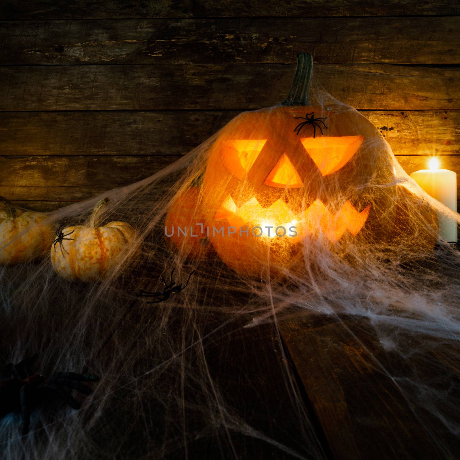 Jack O Lantern Halloween pumpkin , spiders on web and burning candles