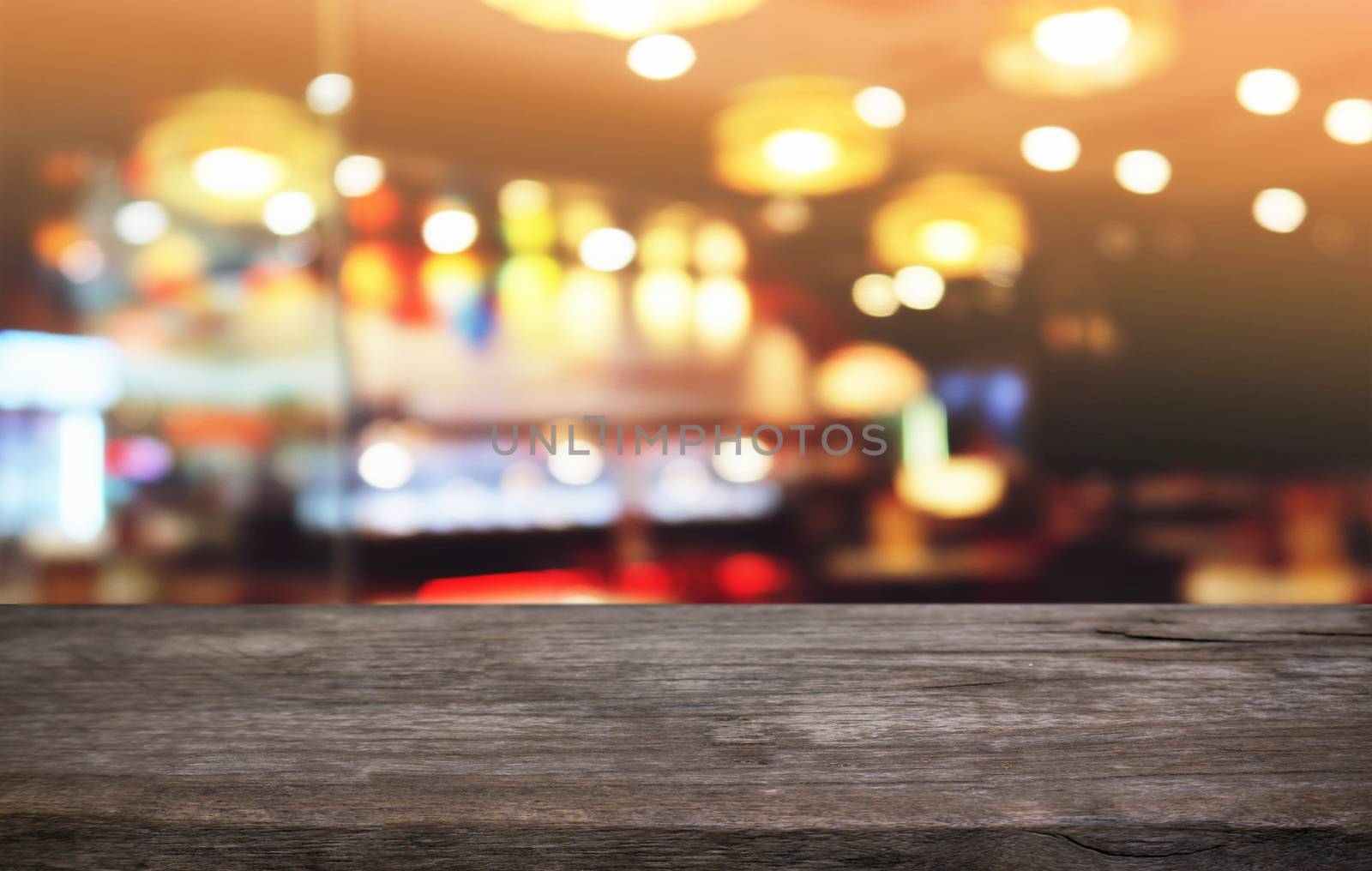 Empty dark wooden table in front of abstract blurred bokeh background of restaurant . can be used for display or montage your products.Mock up for space