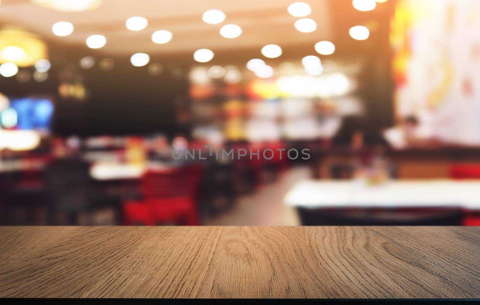 Empty dark wooden table in front of abstract blurred bokeh background of restaurant . can be used for display or montage your products.Mock up for space