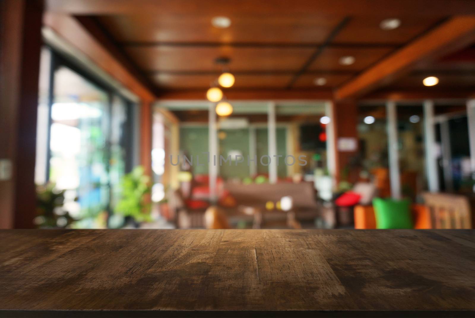 Empty dark wooden table in front of abstract blurred background of cafe and coffee shop interior. can be used for display or montage your products