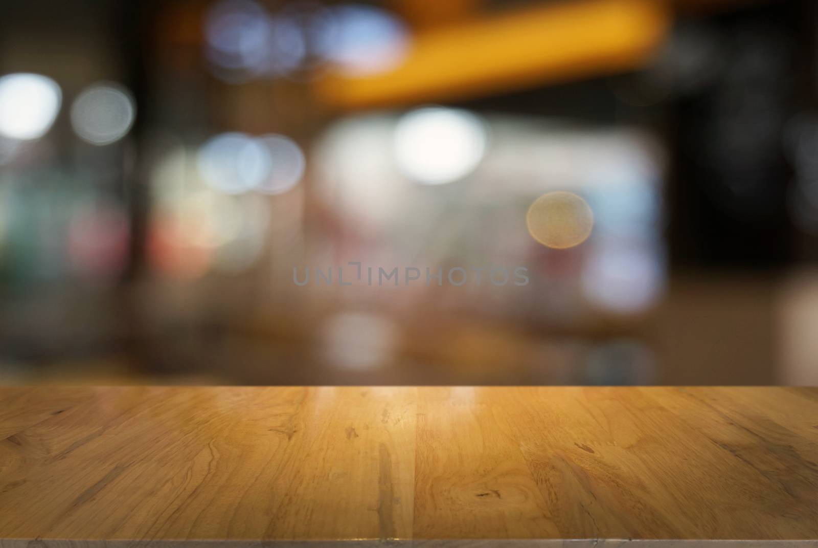 Empty dark wooden table in front of abstract blurred background of cafe and coffee shop interior. can be used for display or montage your products