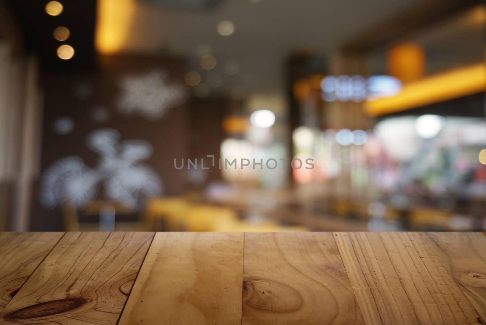 Empty dark wooden table in front of abstract blurred background of cafe and coffee shop interior. can be used for display or montage your products