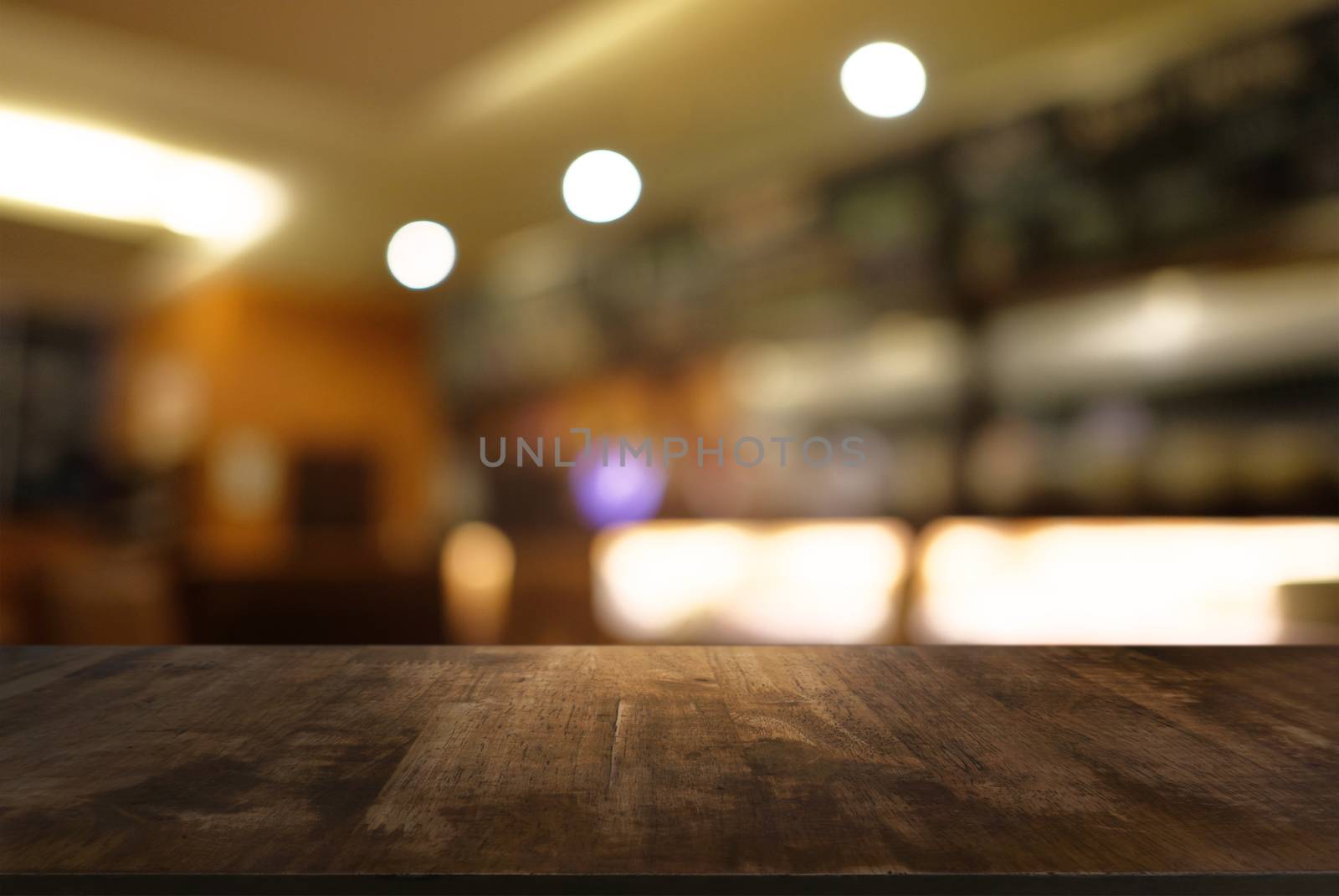 Empty dark wooden table in front of abstract blurred background of cafe and coffee shop interior. can be used for display or montage your products