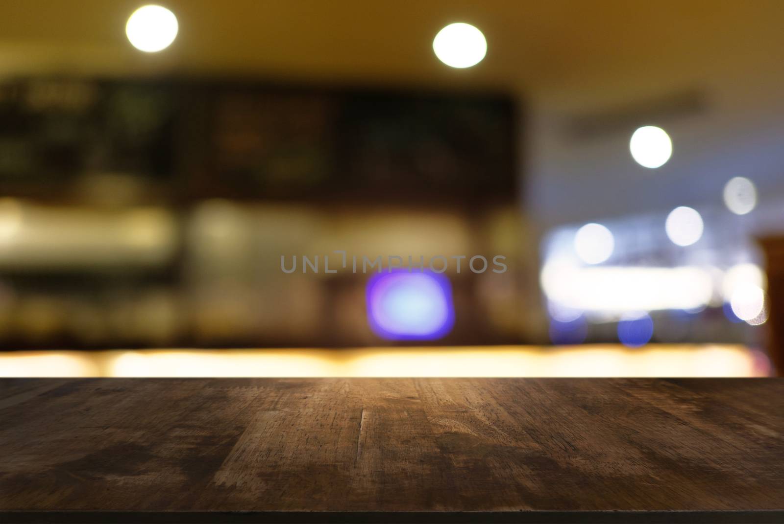 Empty dark wooden table in front of abstract blurred background of cafe and coffee shop interior. can be used for display or montage your products