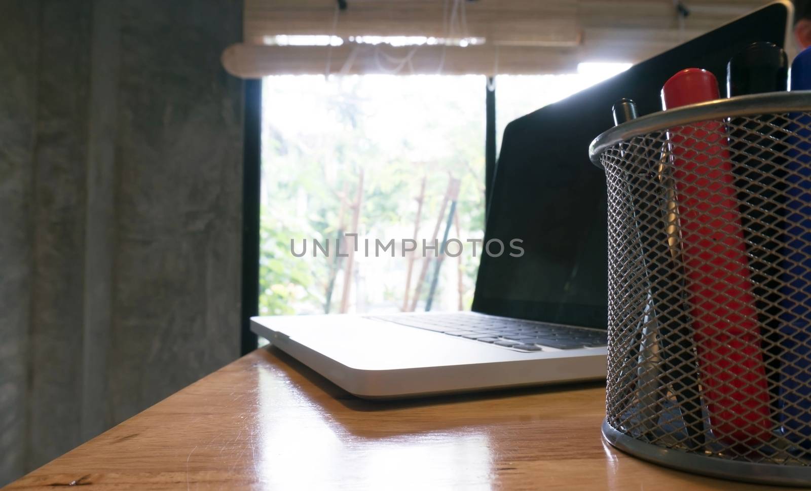 Laptop stands on a wooden table. by peandben