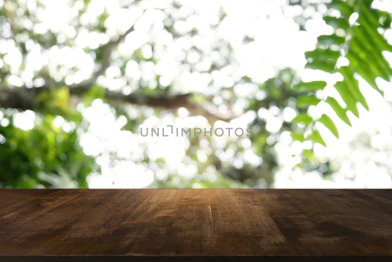 Image of dark wooden table in front of abstract blurred backgrou by peandben