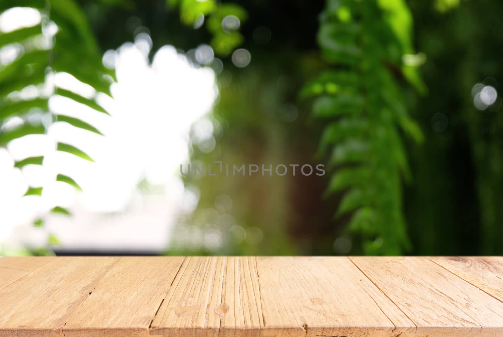 Image of dark wooden table in front of abstract blurred background of outdoor garden lights. can be used for display or montage your products.Mock up for display of product.