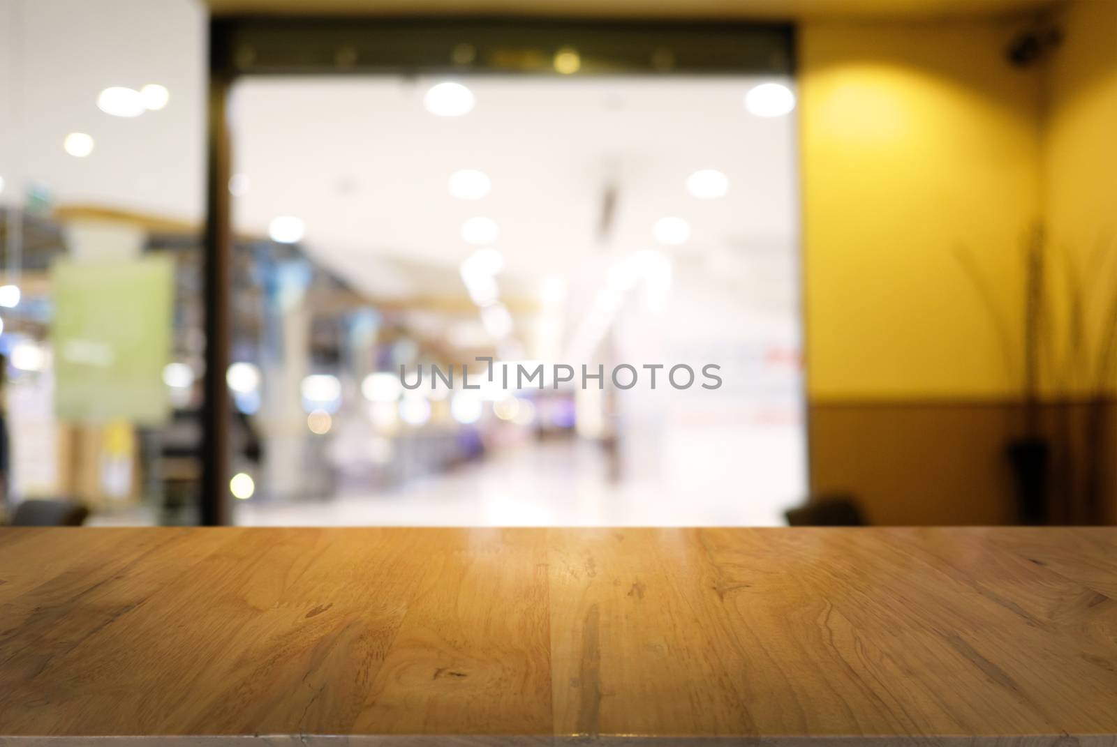 Empty dark wooden table in front of abstract blurred background of coffee shop . can be used for display or montage your products.Mock up for display of product