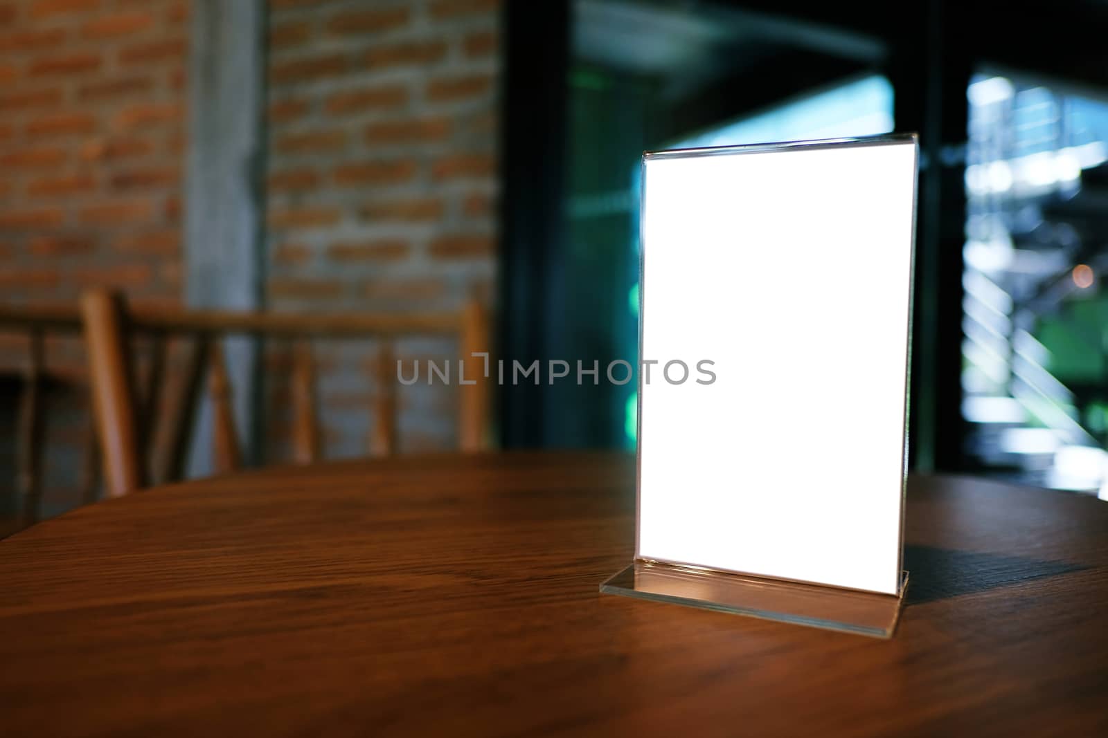 Mock up Menu frame standing on wood table in Bar restaurant cafe. space for text